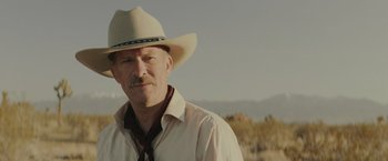 Movie still from “One Ranger” (2023), directed by Jesse V. Johnson – A man in a cowboy hat standing in a field; Close Up shot, Low angle