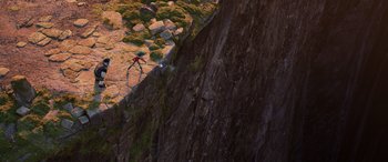 Movie still from “Onward” (2020), directed by Dan Scanlon – A person is walking on a path next to a rock wall; Extreme Wide shot, Overhead angle