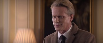 Movie still from “Operation Fortune: Ruse de Guerre” (2023), directed by Guy Ritchie – A person wearing a suit and tie; Close Up shot, Over the shoulder angle