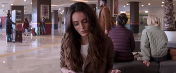 Movie still from “Operation Fortune: Ruse de Guerre” (2023), directed by Guy Ritchie – A beautiful young woman with long brown hair; Close Up shot, Over the shoulder angle