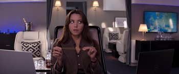 Movie still from “Operation Fortune: Ruse de Guerre” (2023), directed by Guy Ritchie – A woman sitting in a chair holding a piece of wood; Close Up shot, Overhead angle