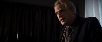 Movie still from “Operation Fortune: Ruse de Guerre” (2023), directed by Guy Ritchie – A person wearing a suit and tie; Close Up shot, Low angle