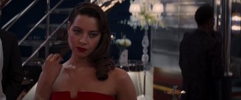 Movie still from “Operation Fortune: Ruse de Guerre” (2023), directed by Guy Ritchie – A woman in a strapless red dress with red lipstick; Close Up shot, Over the shoulder angle