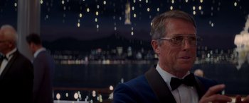 Movie still from “Operation Fortune: Ruse de Guerre” (2023), directed by Guy Ritchie – A person wearing a suit and tie; Close Up shot, Over the shoulder angle