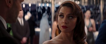 Movie still from “Operation Fortune: Ruse de Guerre” (2023), directed by Guy Ritchie – A beautiful woman with red lipstick looking off to her right; Close Up shot, Over the shoulder angle