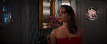 Movie still from “Operation Fortune: Ruse de Guerre” (2023), directed by Guy Ritchie – A woman in a strapless red dress in front of a mirror; Medium shot, Over the shoulder angle