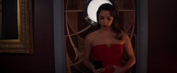Movie still from “Operation Fortune: Ruse de Guerre” (2023), directed by Guy Ritchie – A woman in a strapless dress holding a cell phone; Medium shot, Overhead angle