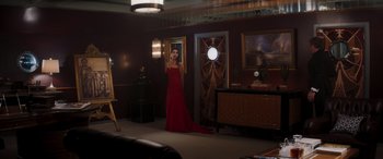 Movie still from “Operation Fortune: Ruse de Guerre” (2023), directed by Guy Ritchie – A woman in a red dress in front of a mirror; Wide shot, Over the shoulder angle