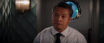 Movie still from “Operation Fortune: Ruse de Guerre” (2023), directed by Guy Ritchie – A person wearing a shirt and a tie; Close Up shot, Over the shoulder angle