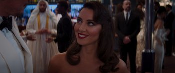 Movie still from “Operation Fortune: Ruse de Guerre” (2023), directed by Guy Ritchie – A beautiful woman with red lipstick smiling for the camera; Close Up shot, Over the shoulder angle