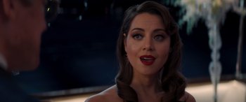 Movie still from “Operation Fortune: Ruse de Guerre” (2023), directed by Guy Ritchie – A beautiful woman with red lipstick looking at the camera; Close Up shot, Over the shoulder angle