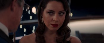 Movie still from “Operation Fortune: Ruse de Guerre” (2023), directed by Guy Ritchie – A beautiful woman with long hair and red lipstick; Close Up shot, Over the shoulder angle