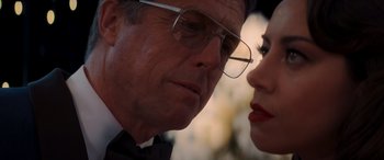 Movie still from “Operation Fortune: Ruse de Guerre” (2023), directed by Guy Ritchie – An older man and a younger woman looking at each other; Close Up shot, Over the shoulder angle