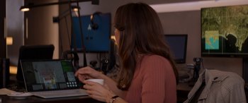 Movie still from “Operation Fortune: Ruse de Guerre” (2023), directed by Guy Ritchie – A woman sitting at a table with a cup in her hand; Medium shot, Over the shoulder angle