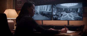 Movie still from “Operation Fortune: Ruse de Guerre” (2023), directed by Guy Ritchie – A woman sitting in front of a computer monitor; Medium shot, Over the shoulder angle