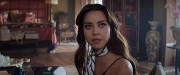 Movie still from “Operation Fortune: Ruse de Guerre” (2023), directed by Guy Ritchie – A beautiful woman with long brown hair wearing a neck scarf; Close Up shot, Over the shoulder angle