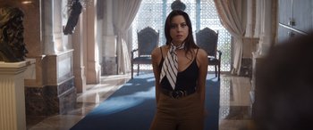 Movie still from “Operation Fortune: Ruse de Guerre” (2023), directed by Guy Ritchie – A woman standing in front of a window wearing a neck tie; Medium shot, Low angle