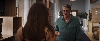 Movie still from “Operation Fortune: Ruse de Guerre” (2023), directed by Guy Ritchie – An older man talking to a young woman in front of a mirror; Medium shot, Over the shoulder angle