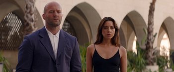 Movie still from “Operation Fortune: Ruse de Guerre” (2023), directed by Guy Ritchie – A man and a woman standing next to each other in front of an archway; Medium shot, Low angle