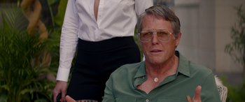 Movie still from “Operation Fortune: Ruse de Guerre” (2023), directed by Guy Ritchie – A person wearing a green shirt; Close Up shot, Over the shoulder angle