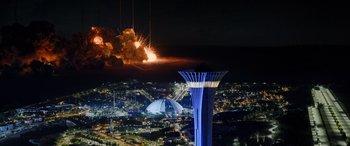 Movie still from “Operation Fortune: Ruse de Guerre” (2023), directed by Guy Ritchie – An aerial view of a city with a fireworks display in the background; Extreme Wide shot, Low angle