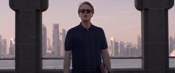 Movie still from “Operation Fortune: Ruse de Guerre” (2023), directed by Guy Ritchie – A man standing in front of a city skyline; Medium shot, Low angle