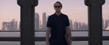 Movie still from “Operation Fortune: Ruse de Guerre” (2023), directed by Guy Ritchie – A man standing in front of a city skyline; Medium shot, Low angle