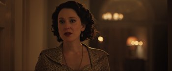 Movie still from “Operation Mincemeat” (2021), directed by John Madden – A person with curly hair wearing a dress; Close Up shot, Over the shoulder angle