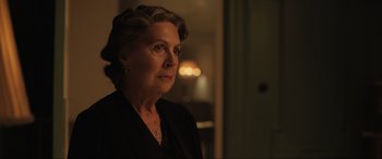 Movie still from “Operation Mincemeat” (2021), directed by John Madden – An older woman in a black jacket looking at the camera; Close Up shot, Over the shoulder angle