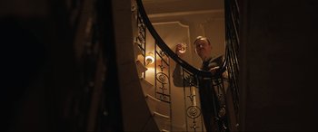 Movie still from “Operation Mincemeat” (2021), directed by John Madden – A man standing on top of a spiral stair case; Medium shot, Low angle