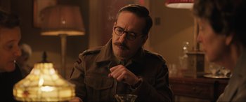 Movie still from “Operation Mincemeat” (2021), directed by John Madden – A man in a military uniform smoking a cigarette; Close Up shot, Low angle