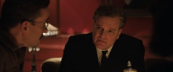 Movie still from “Operation Mincemeat” (2021), directed by John Madden – A person wearing a suit and tie; Close Up shot, Low angle
