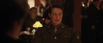 Movie still from “Operation Mincemeat” (2021), directed by John Madden – A man in a military uniform is looking at the camera; Medium shot, High angle