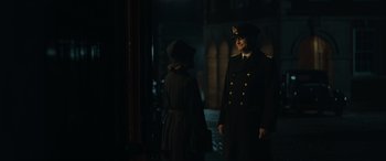 Movie still from “Operation Mincemeat” (2021), directed by John Madden – A man and a woman standing next to each other in front of a building; Medium shot, Over the shoulder angle