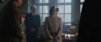 Movie still from “Operation Mincemeat” (2021), directed by John Madden – A man and a woman standing next to each other in front of a window; Medium shot, Over the shoulder angle