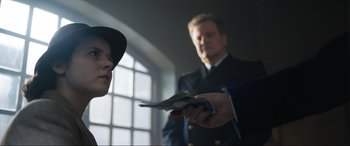 Movie still from “Operation Mincemeat” (2021), directed by John Madden – A man in a navy uniform holding money and looking at another man in a navy uniform holding money; Close Up shot, Over the shoulder angle