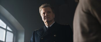 Movie still from “Operation Mincemeat” (2021), directed by John Madden – A person wearing a suit and tie; Close Up shot, Low angle