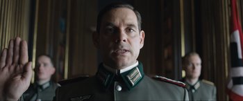 Movie still from “Operation Mincemeat” (2021), directed by John Madden – A person wearing a military uniform; Close Up shot, Low angle