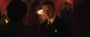 Movie still from “Operation Mincemeat” (2021), directed by John Madden – A man wearing a suit and tie in front of a mirror; Close Up shot, Over the shoulder angle