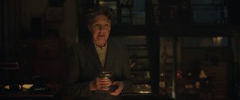 Movie still from “Operation Mincemeat” (2021), directed by John Madden – An older woman is holding a cup in her hands; Medium shot, Low angle
