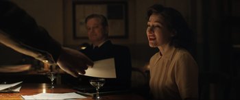 Movie still from “Operation Mincemeat” (2021), directed by John Madden – A woman sitting at a table with a glass of wine; Medium shot, Over the shoulder angle