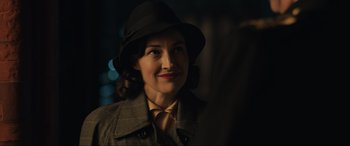 Movie still from “Operation Mincemeat” (2021), directed by John Madden – A woman wearing a hat and a coat; Close Up shot, Over the shoulder angle