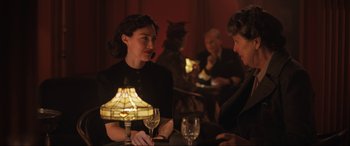 Movie still from “Operation Mincemeat” (2021), directed by John Madden – Two women are sitting at a table with wine glasses in front of them; Medium shot, Over the shoulder angle