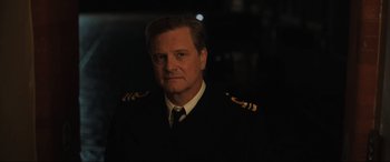 Movie still from “Operation Mincemeat” (2021), directed by John Madden – A person wearing a suit and tie; Close Up shot, Over the shoulder angle