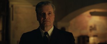 Movie still from “Operation Mincemeat” (2021), directed by John Madden – A person wearing a suit and tie; Close Up shot, Low angle