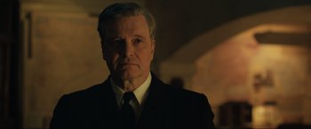 Movie still from “Operation Mincemeat” (2021), directed by John Madden – A person wearing a suit and tie; Close Up shot, Low angle