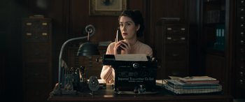 Movie still from “Operation Mincemeat” (2021), directed by John Madden – A woman sitting at a desk with a typewriter; Medium shot, High angle