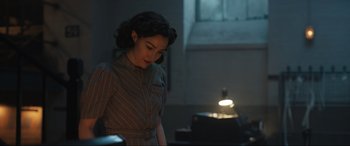 Movie still from “Operation Mincemeat” (2021), directed by John Madden – A woman standing in front of an oven in a room; Medium shot, Over the shoulder angle