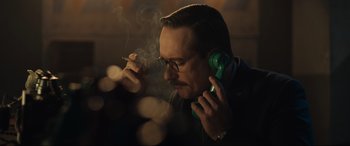 Movie still from “Operation Mincemeat” (2021), directed by John Madden – A man smoking a cigarette while talking on a phone; Close Up shot, Low angle