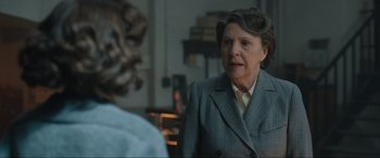 Movie still from “Operation Mincemeat” (2021), directed by John Madden – An older woman wearing a suit talking to a younger woman; Close Up shot, Over the shoulder angle